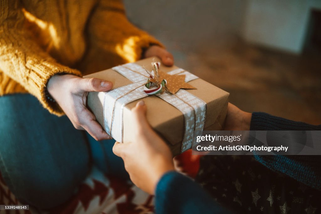 Hands giving christmas gift close-up