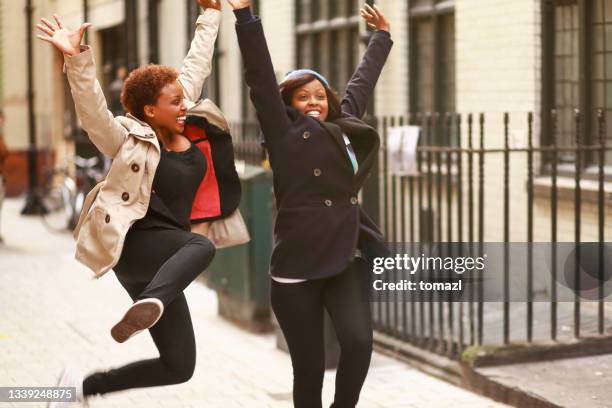 african american females jumping of joy - jump for joy stock pictures, royalty-free photos & images