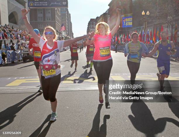 Erin Chatham, and survivor Heather Abbott cross the finish line of The 118th running of the Boston Marathon and the first since the bombing at the...