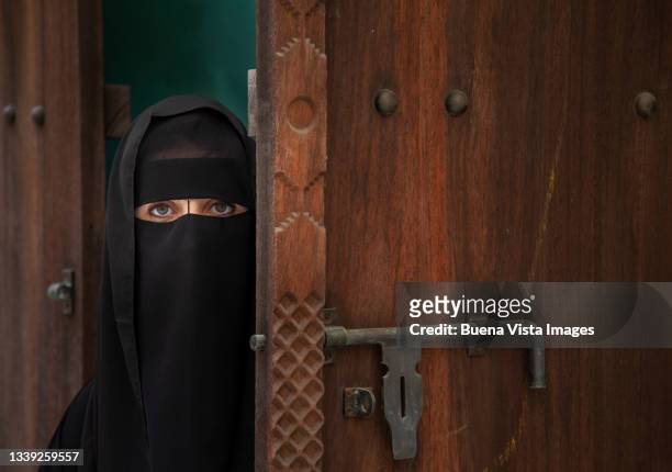 arab woman wearing abaya and hijab - vista posterior stock-fotos und bilder