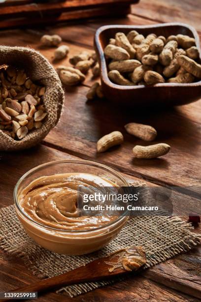 peanut butter on a glass bowl on rustic background - nut butter stock pictures, royalty-free photos & images