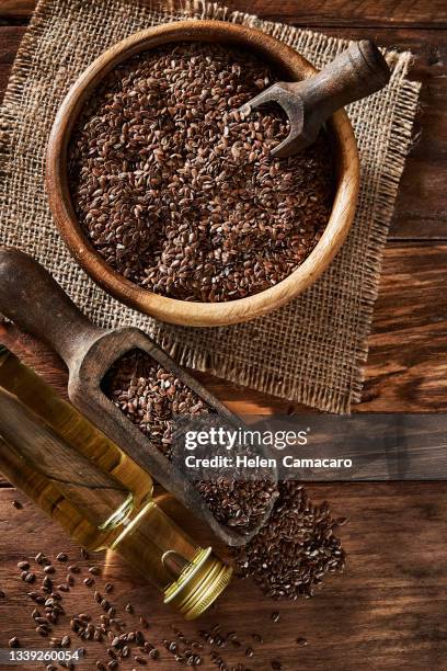 top view of flax seeds in a bowl and linseed oil on wooden backdrop. flaxseed dietary fiber - cereales stock pictures, royalty-free photos & images