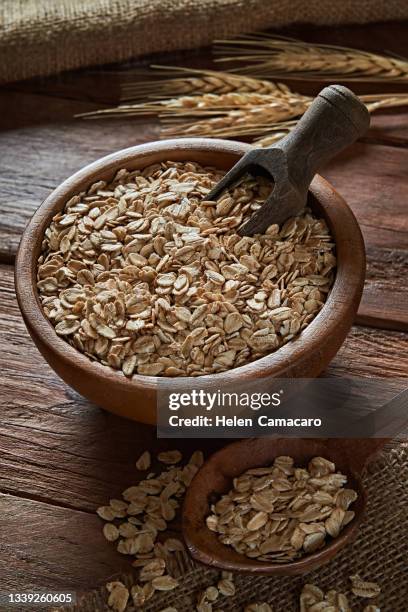 uncooked oat flakes on rustic wooden table - cereales stock pictures, royalty-free photos & images