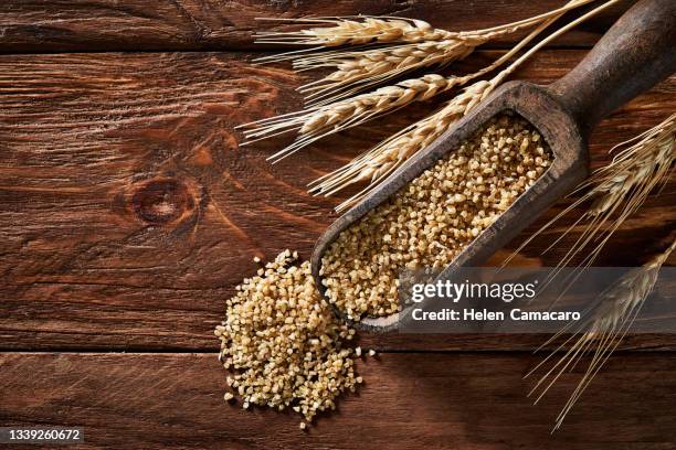 uncooked wheat grain on rustic wooden table - cereales stock pictures, royalty-free photos & images