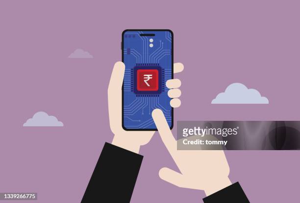 hand, die ein mobiltelefon für die verwendung der digitalen währung indien-rupie hält - indian money stock-grafiken, -clipart, -cartoons und -symbole