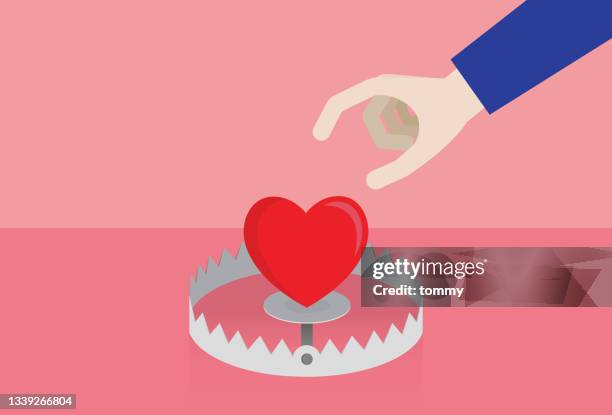 hand picks up the heart from the trap - stuck stock illustrations