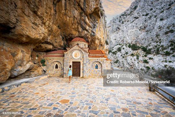 woman admiring the old stone church, greece - kreta stockfoto's en -beelden