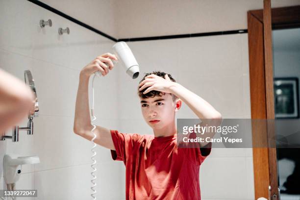 boy with hair dryer in bathroom - hair dryer stock photos et images de collection