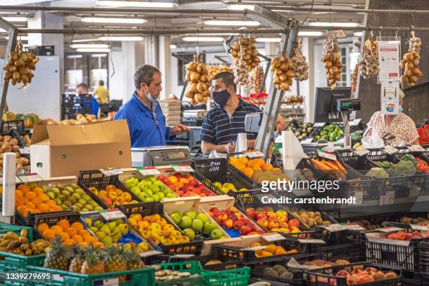 greengrocer waiting for customers at a market stall - general views of shoppers during el buen fin mexicos black friday stockfoto's en -beelden