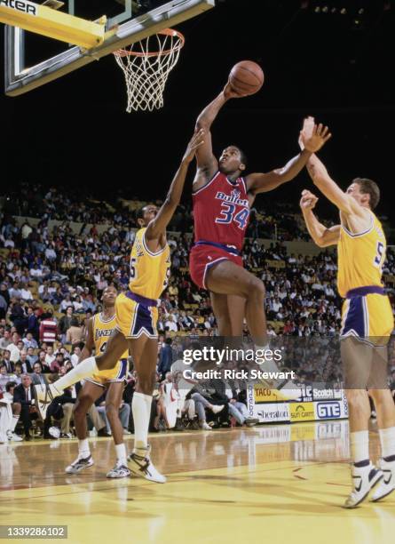 John Williams, Small Forward for the Washington Bullets drives to the basket above Billy Thompson and Mike Smrek during their NBA Pacific Division...