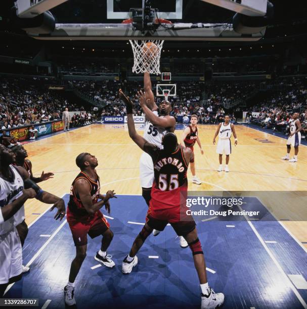 Jahidi White, Power Forward for the Washington Wizards attempts to make a one handed lay up to the basket over Dikembe Mutombo, Center for the...