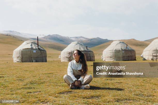 woman traveler enjoying sunny summer day at the yurt camp in the mountains of kyrgyzstan - ger stock pictures, royalty-free photos & images