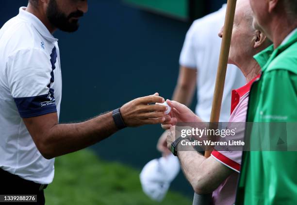 Francesco Laporta of Italy hands his ball to a walking scorer after his round during Day One of The BMW PGA Championship at Wentworth Golf Club on...