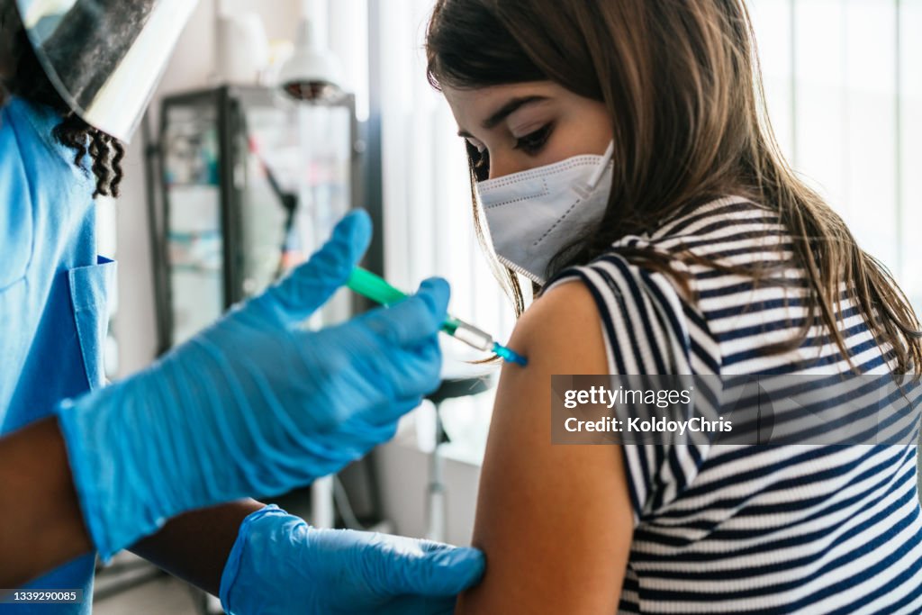 Female patient reciving a shot in vaccination center