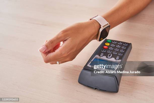 close-up of an authorized contactless payment made with a smart watch on a wooden surface. - wooden surface finishes foto e immagini stock