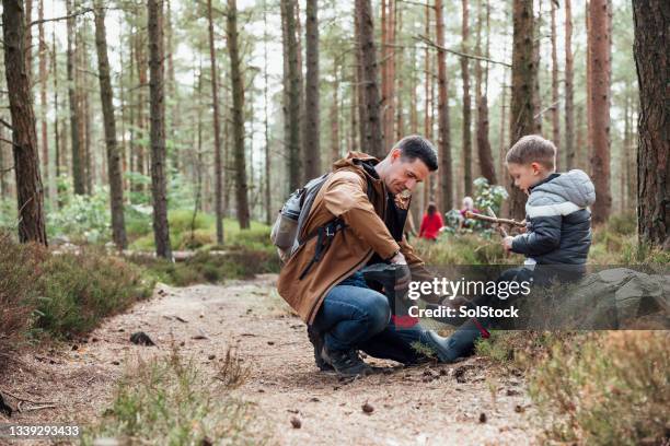 emptying out stones from shoes - family shoes stockfoto's en -beelden