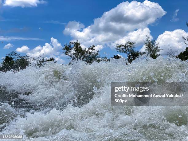 low angle view of waves splashing on shore against sky,bauchi,nigeria - nigeria landscape stock pictures, royalty-free photos & images
