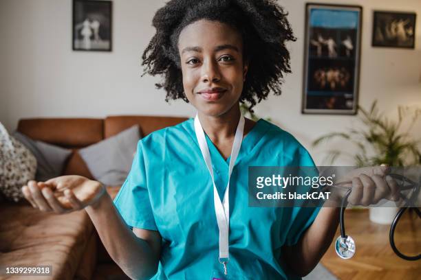 a portrait of a young doctor at home talking to a patient via video call. personal perspective - personal perspective doctor stock pictures, royalty-free photos & images