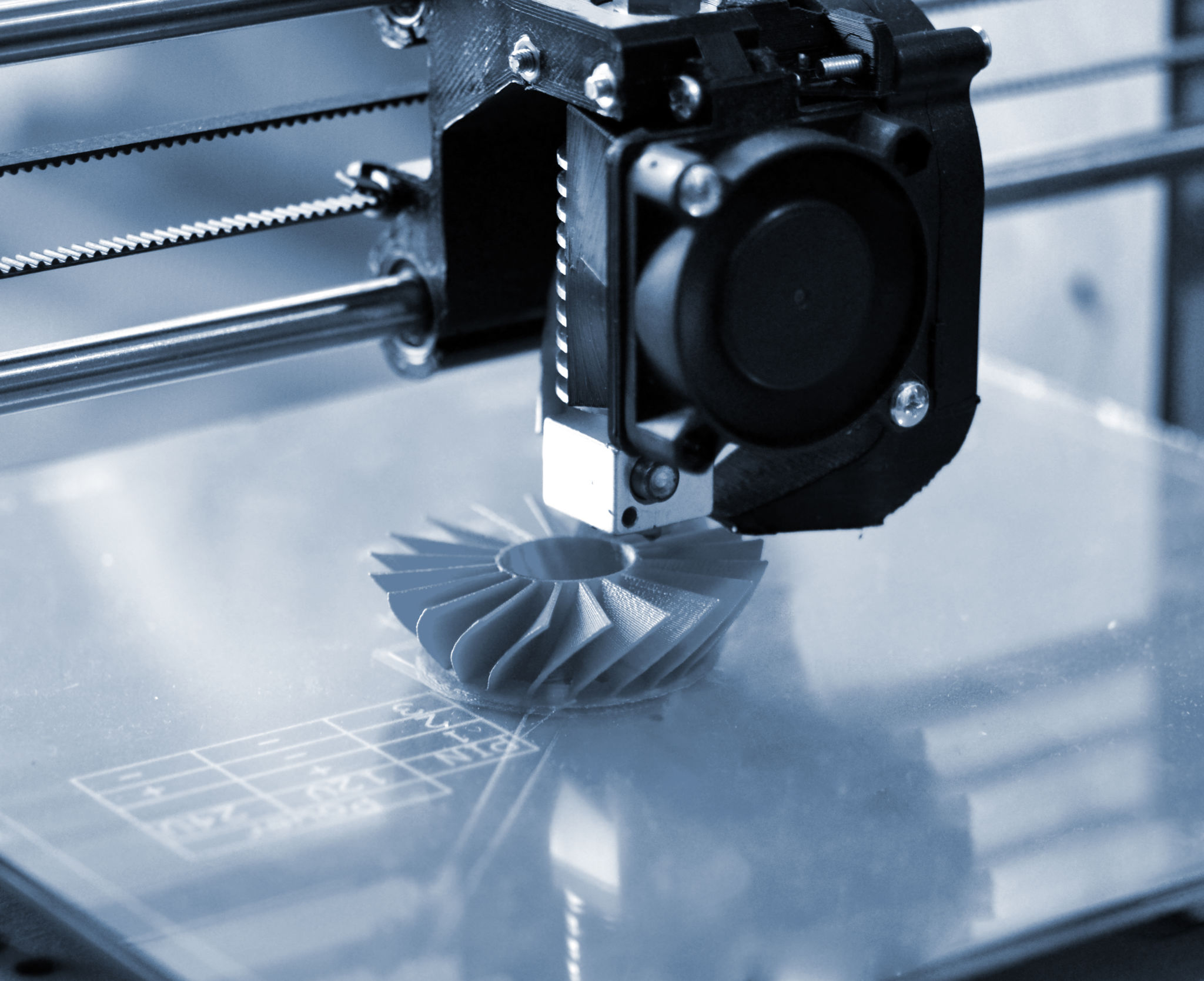 3D printer prints blue shapes on a blue backgroun 3D printer prints blue shapes on a blue backgroun