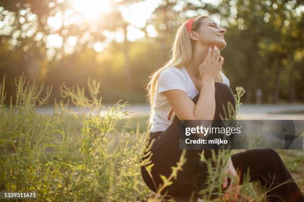 frau, die im freien sitzt und an einer pollenallergie leidet - hautausschlag stock-fotos und bilder