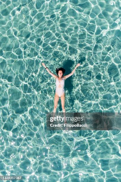 a woman is relaxing in a transparent turquoise sea - palma mallorca stock pictures, royalty-free photos & images