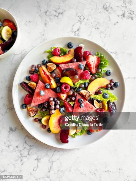 plate of fruit salad on white, marble background - macedonia postre fotografías e imágenes de stock
