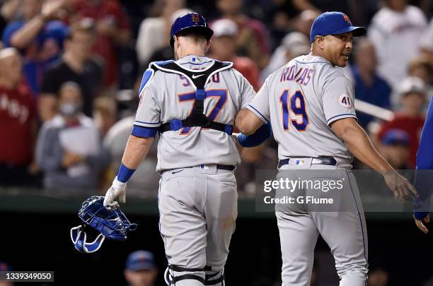 Chance Sisco of the New York Mets walks off the field with manager Luis Rojas after being injured during the game against the Washington Nationals at...