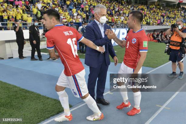 Claudio Baeza and Jean Meneses of Chile greet Reinaldo Rueda head coach of Colombia prior a match between Colombia and Chile as part of South...