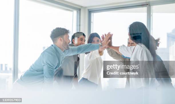 l’équipe d’affaires célèbre le succès avec un high five. - avantage photos et images de collection