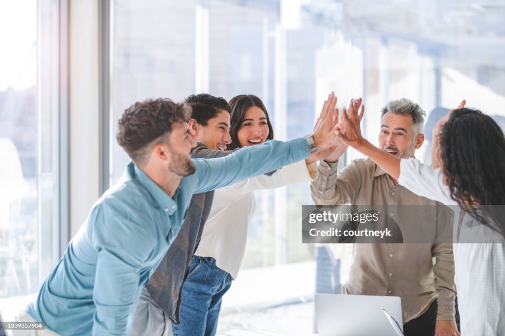 Business team celebrating success with a high five.