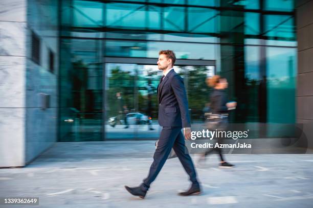 caucasian businessman in early 30s on the move - business woman side stockfoto's en -beelden