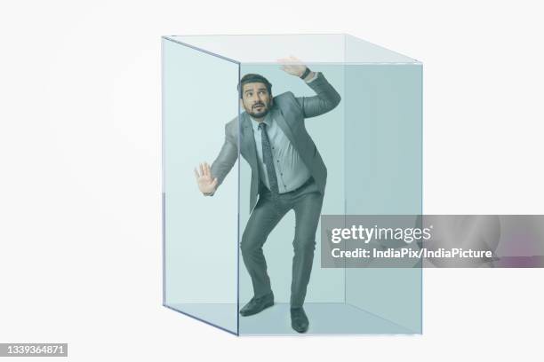 portrait of a man in formal business suit trapped in a transparent cube. - breaking out of the box stock pictures, royalty-free photos & images