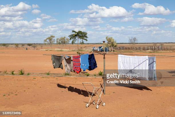 old clothesline with clothes and old clothes basket  set in a background of vibrant red  dirt and blue sky,. - washing line stock pictures, royalty-free photos & images