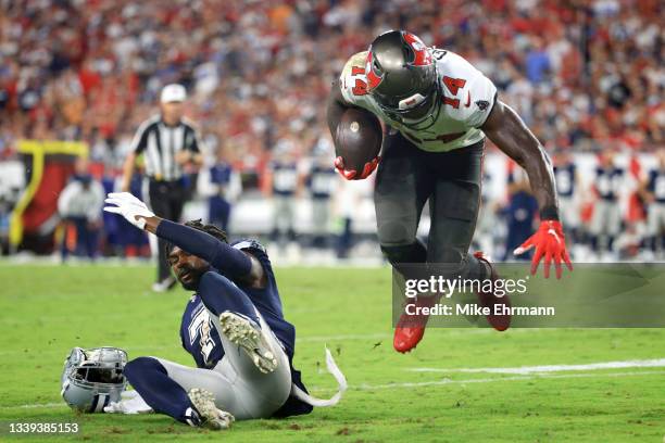 Chris Godwin of the Tampa Bay Buccaneers carries the ball as Trevon Diggs of the Dallas Cowboys loses his helment during the third quarter at Raymond...