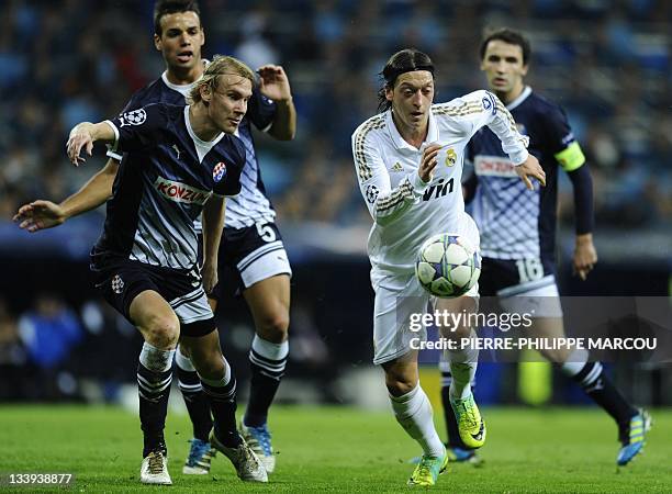 Real Madrid's German midfielder Mesut Ozil vies with Dinamo Zagreb's Dinamo Zagreb's defender Domagoj Vida during the UEFA Champions league first leg...