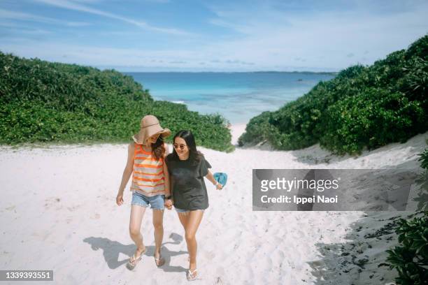 mother and daughter walking together on tropical beach, okinawa, japan - japan 12 years girl stock pictures, royalty-free photos & images