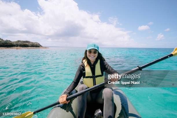 cheerful girl enjoying sea kayaking on tropical water, okinawa, japan - girl rowing boat photos et images de collection