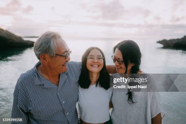 family having a good time on beach at dusk - asian grandparents foto e immagini stock