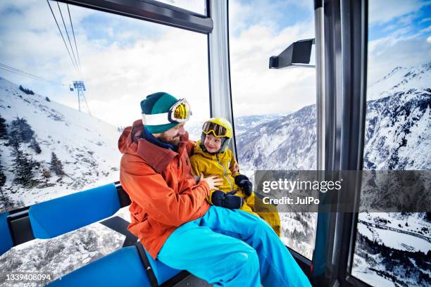 father with son in ski lift at ski resort - ski lift stock pictures, royalty-free photos & images