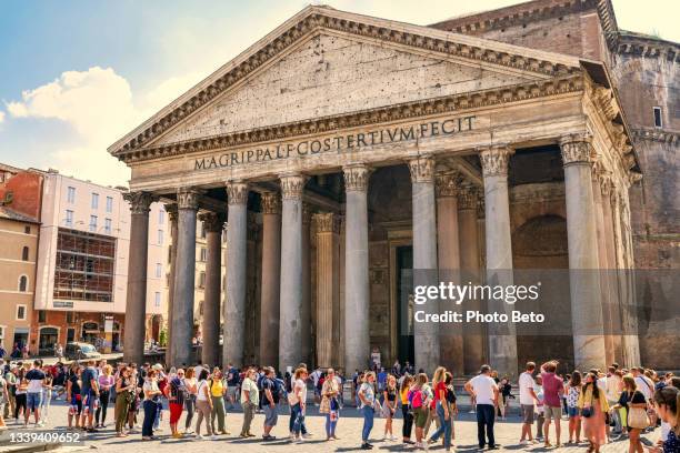 dozens of tourists wait in line to visit the majestic roman pantheon in the historic heart of rome - pantheon stock pictures, royalty-free photos & images
