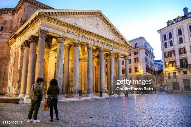 an evening view of some tourists in front of the majestic roman pantheon in the heart of rome - pantheon rome stockfoto's en -beelden