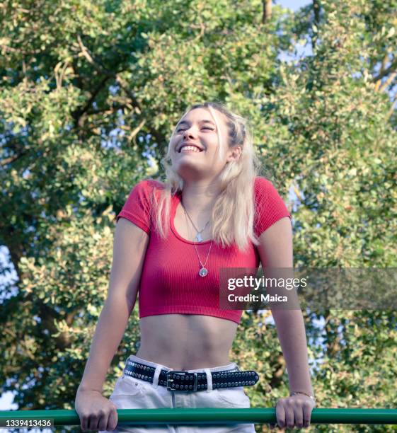 girl climbing a gymnastics bar in a park - one teenage girl only stock pictures, royalty-free photos & images