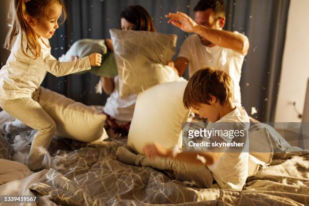 happy family having a pillow fight in the bedroom. - luta de almofada imagens e fotografias de stock