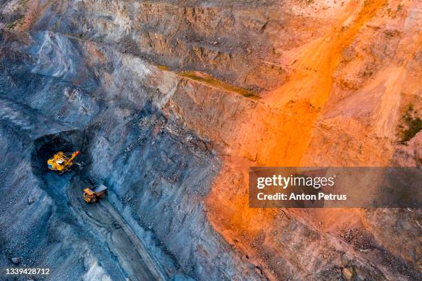 aerial view of open pit iron ore and heavy mining equipment. - natural phenomena stock pictures, royalty-free photos & images