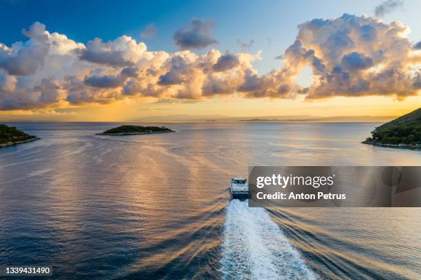 ferry at dawn near the coastline of vis island at sunset. croatia - vis fotografías e imágenes de stock