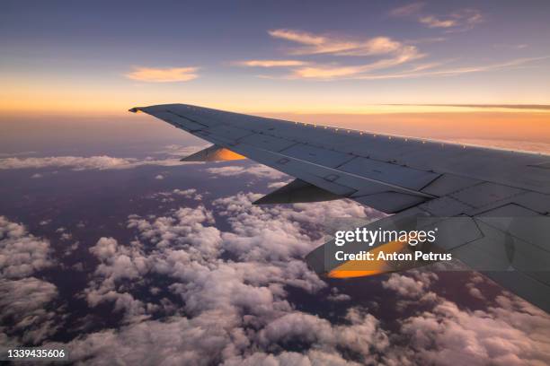 view from the airplane window to the wing at sunset - low angle view of airplane stock pictures, royalty-free photos & images