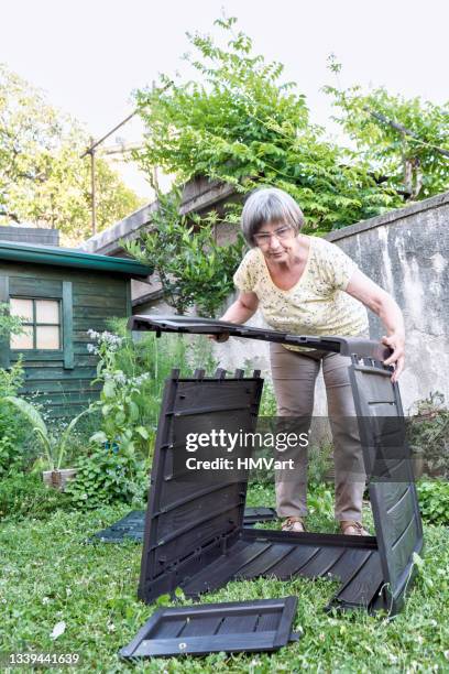 une femme âgée dans le jardin assemble le nouveau bac à compost - biodegradable photos et images de collection