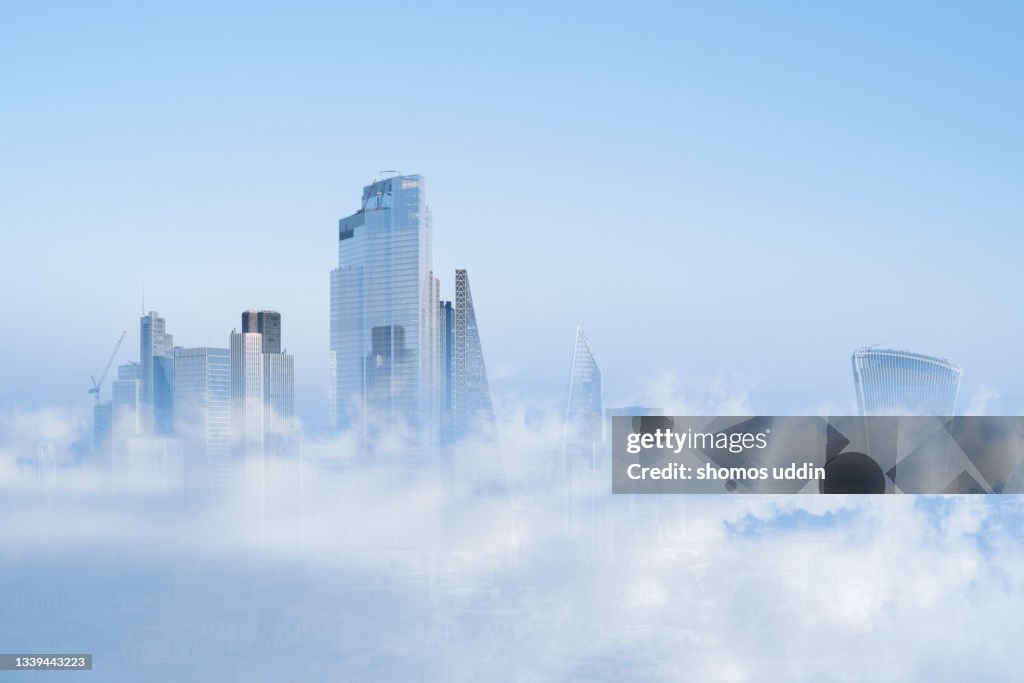 Multi layered cityscape of London skyline emerging through clouds