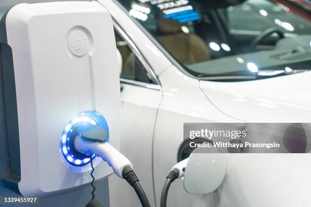 charging modern electric car on the street which are the future of the automobile - red car wire fotografías e imágenes de stock