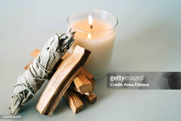 palo santo sticks, white sage and burning candle on gray background. set for aromatherapy and rituals. copy space for your design. top view and close-up - smudging ceremony stock pictures, royalty-free photos & images